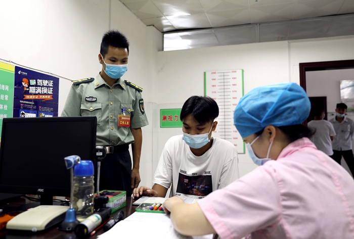 8月4日,在广西柳州市融安县人民医院征兵体检站,一名应征青年正在进行